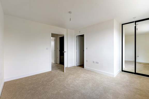 A room with a carpeted floor and white walls.