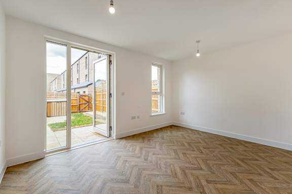 A room with a wooden floor and a sliding glass door.
