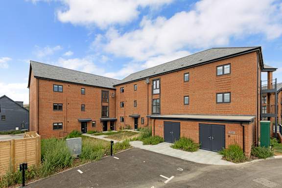 A large red brick building with a parking lot in front.