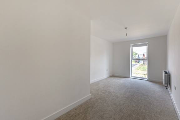 A room with a window showing a view of a residential area.