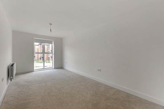 A room with a carpeted floor and a window.