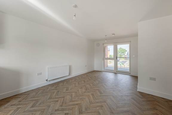 A room with a herringbone patterned floor and a sliding glass door.
