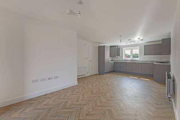 A room with wooden flooring and a window.