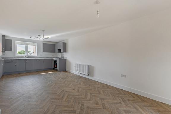 A room with a wooden floor and a window.