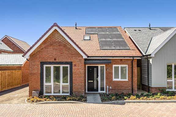 A red brick house with a black door and windows.