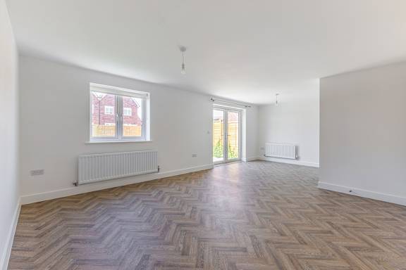 A room with a wooden floor and a window.