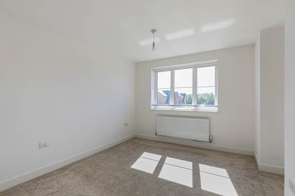 A room with a window and a radiator on the wall.