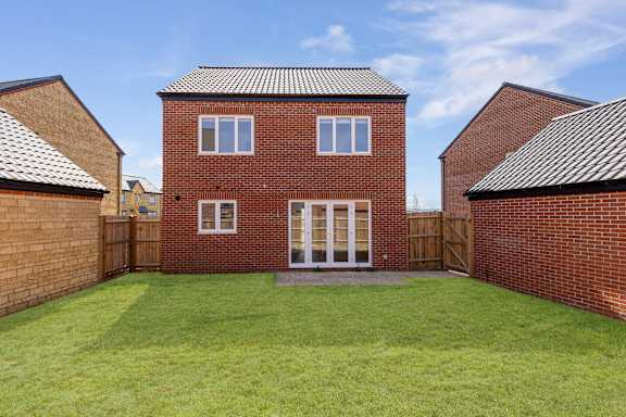 A red brick house with a white door and windows.
