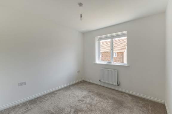 A room with a window and a radiator on the floor.