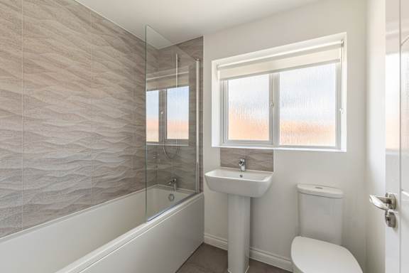 A bathroom with a white toilet, sink, and bathtub.