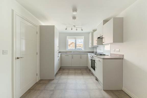 A kitchen with white cabinets and appliances.