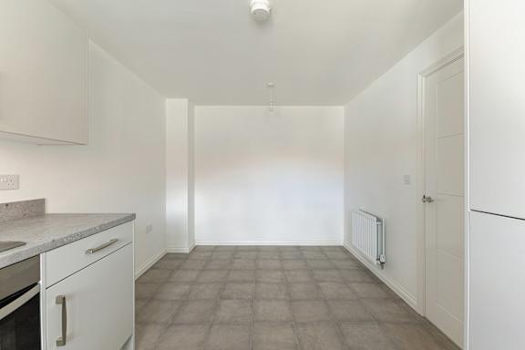 A kitchen with white appliances and cabinets.
