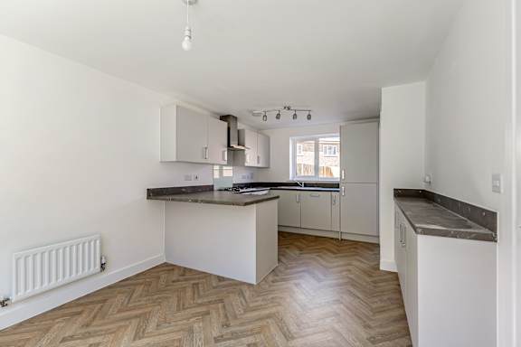A kitchen with a black counter top and white cabinets.