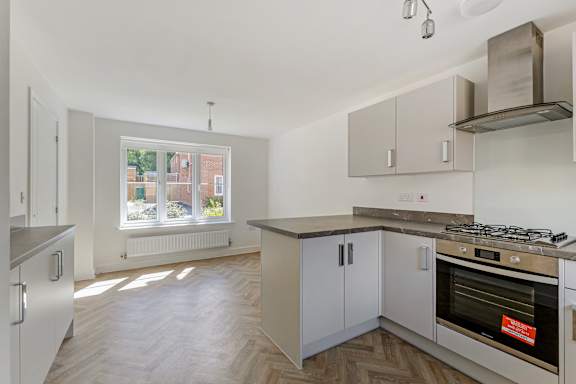 A kitchen with a stove top oven and a window.