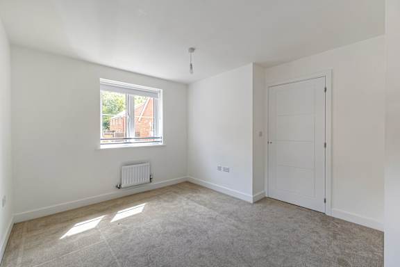 A room with a window and a radiator on the wall.