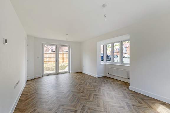 A room with a wooden floor and a window.