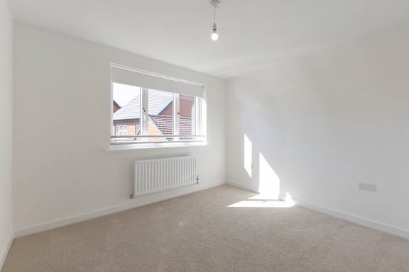 A room with a window and a radiator on the wall.