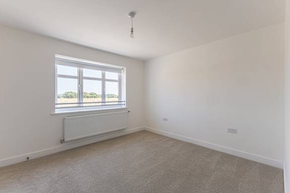 A room with a window and a radiator on the wall.