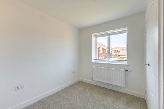 A room with a window and a radiator on the wall.