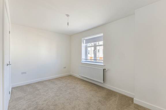 A room with a window and a radiator on the wall.