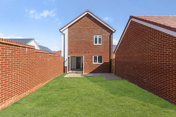 A red brick house with a green lawn in front.