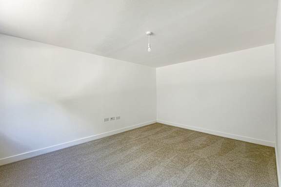 A room with a carpeted floor and white walls.