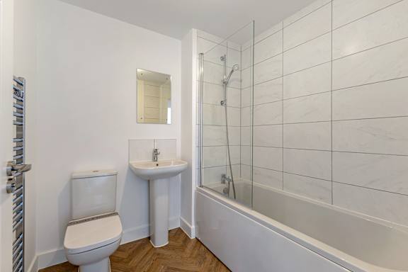 A white bathroom with a toilet, sink, and bathtub.