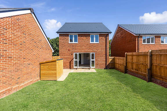A house with a brown fence and a green lawn.
