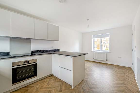A kitchen with a black countertop and white cabinets.