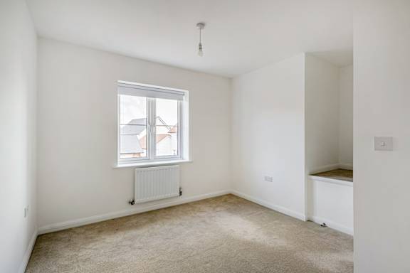 A white room with a window and a radiator.