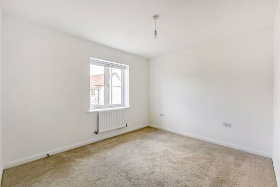 A room with a window and a radiator on the wall.