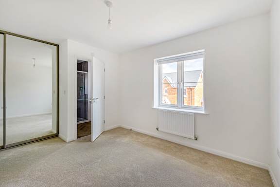 A room with a window, a radiator, and a sliding door.