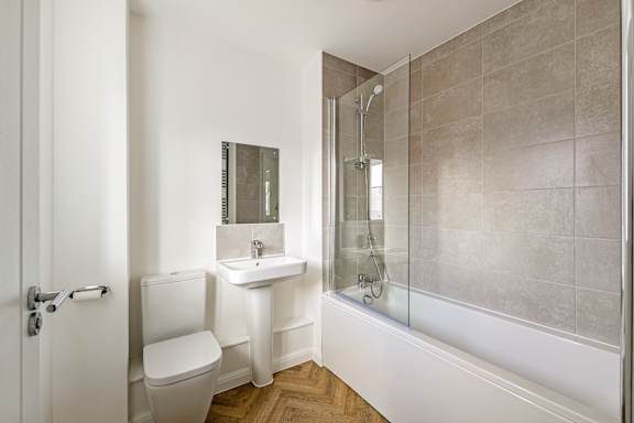 A bathroom with a toilet, sink, and shower.