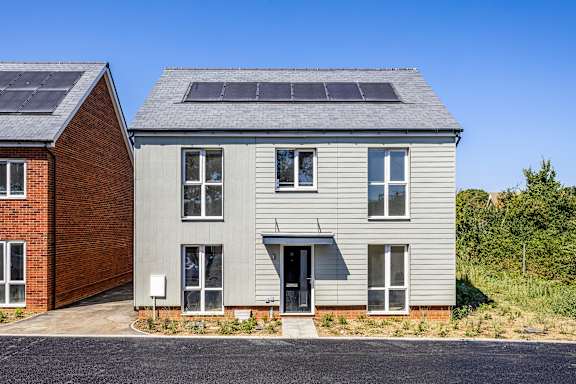A modern house with solar panels on the roof.