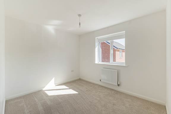 A room with a window and a radiator on the floor.