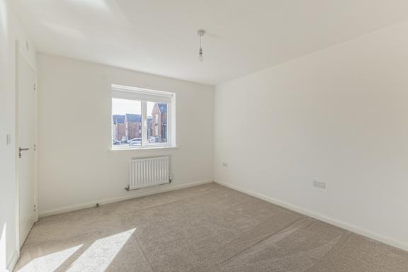 A room with a window and a radiator on the floor.