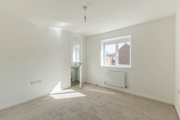 A room with a window and a radiator on the wall.