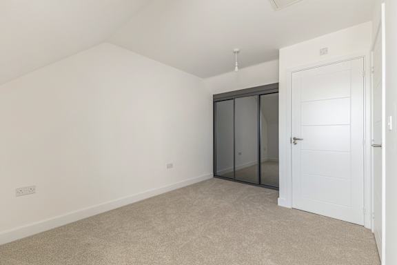 A room with a white door and a black framed window.