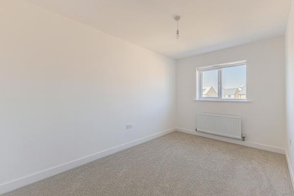 A room with a window and a radiator on the wall.