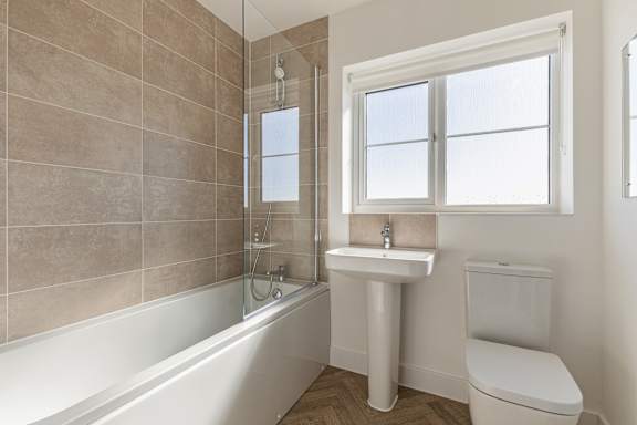 A bathroom with a tub, toilet, and sink.