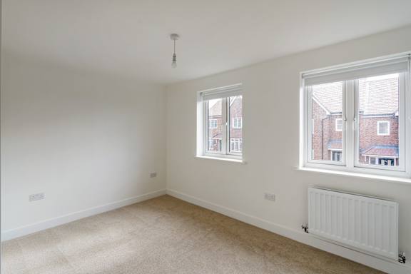 A room with a window and a radiator on the wall.