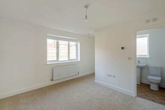 A white room with a window and a radiator.