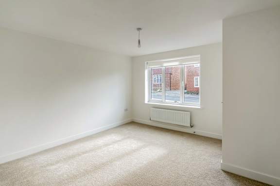 A room with a window and a radiator on the floor.