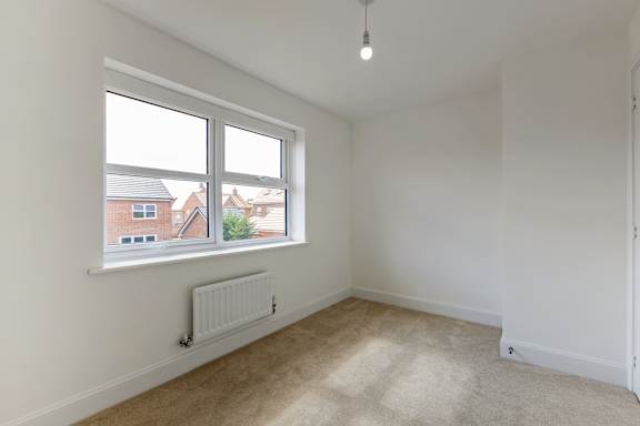 A room with a window and a radiator on the wall.