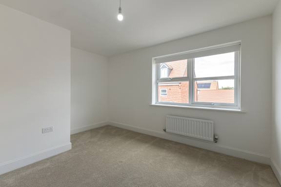 A room with a window and a radiator on the wall.
