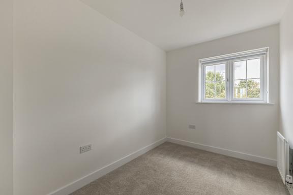 A room with a window and a radiator on the wall.