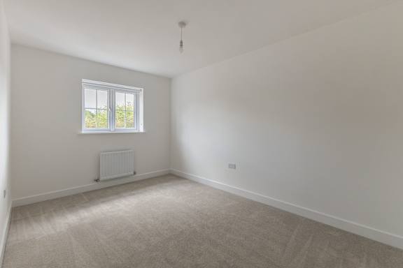 A room with a window and a radiator on the wall.