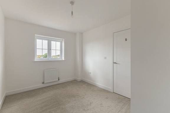 A room with a window and a radiator on the wall.