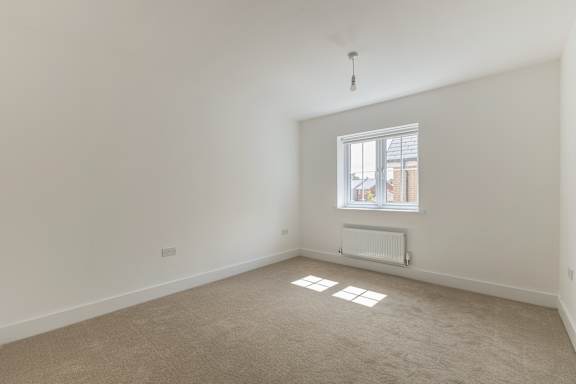 A room with a window and a radiator on the floor.