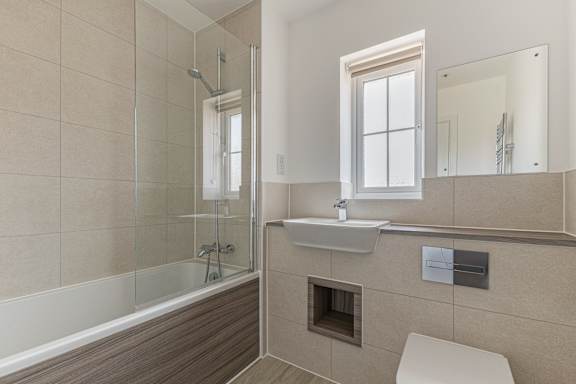 A modern bathroom with a walk-in shower and a toilet.